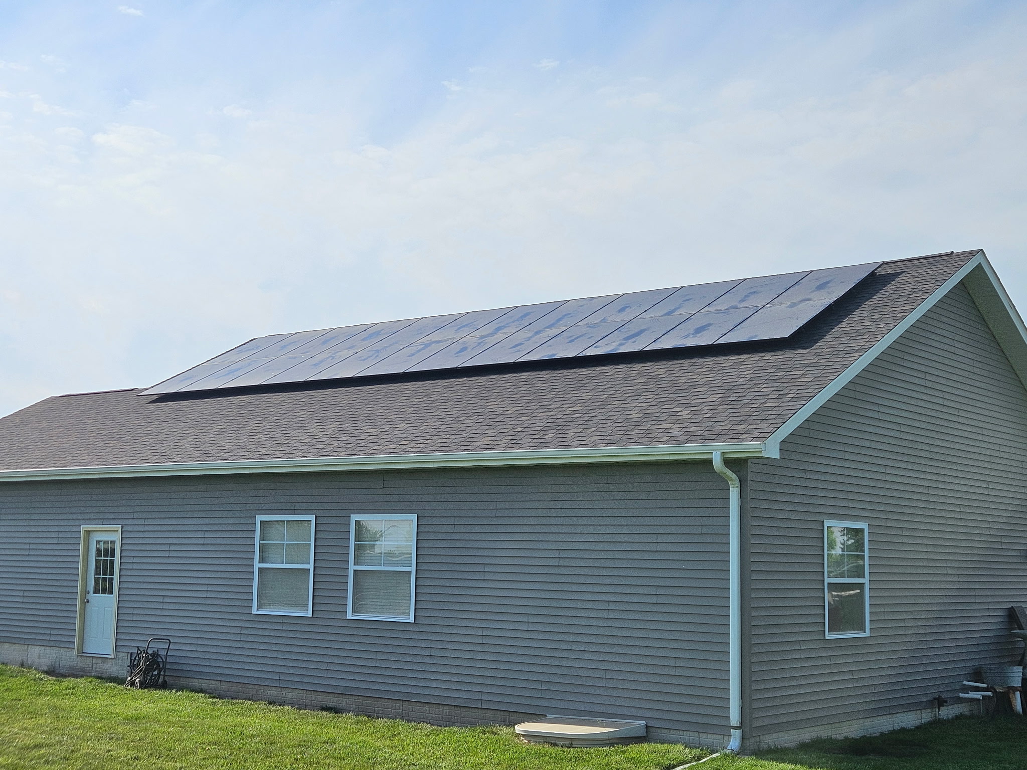 Home with solar panels before roof replacement Ottumwa